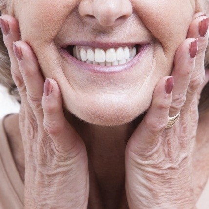 Woman with dental implant tooth replacement framing smile