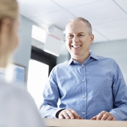 Man discussing the cost of dental implants with dentistry team member