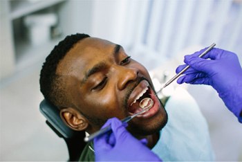 Closeup of dentist using tools to examine patient's teeth