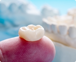 Close up of a dental crown resting on a finger
