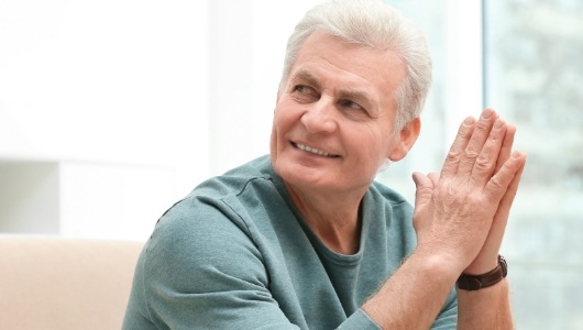 Smiling older man wearing light green sweater