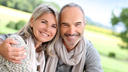 Older man and woman smiling together outdoors