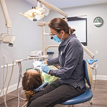 Woman smiling at dentist during dental checkup and teeth cleaning visit