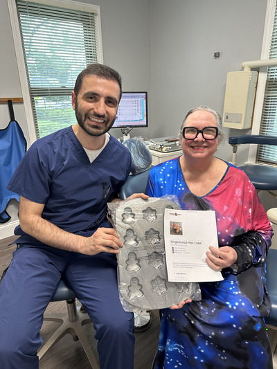 Dentist and patient smiling and holding a cookie cutter tray