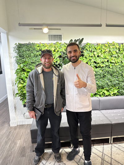 Dentist and patient smiling and giving thumbs up
