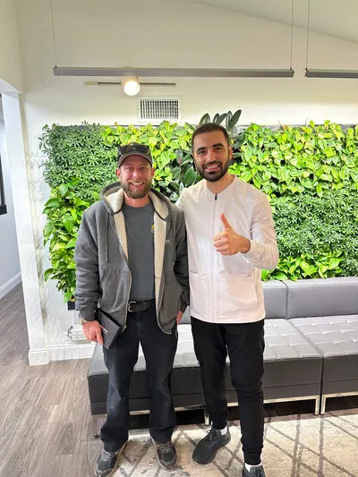 Dentist and patient smiling and giving thumbs up