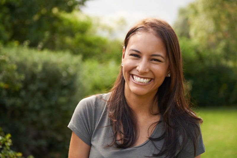 Woman smiling after getting dental implants