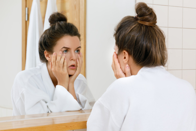 Patient looking tired in the mirror due to sleep apnea