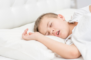 Little boy lying in bed and snoring