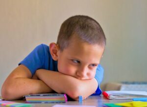 Tired boy struggling with schoolwork 